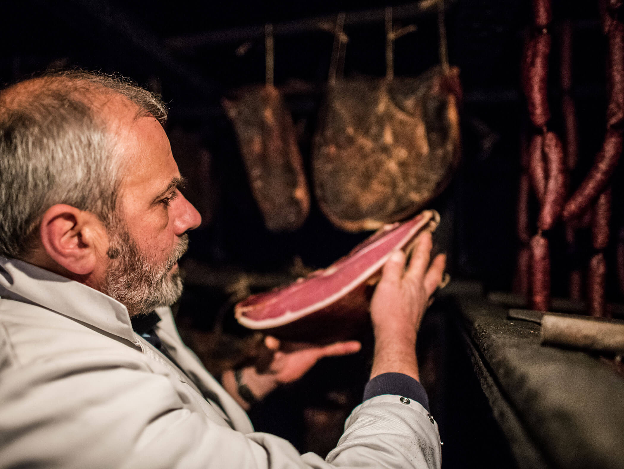 Man holding a side of bacon in his hand - detail - Ariane's Guesthouse